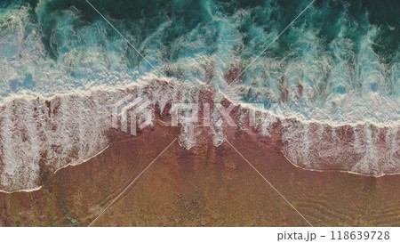 Aerial view turquoise green ocean waves crashing on beautiful pink orange sand beach. Scenery beauty of wild nature. Dark water foam waves break wash coastline. Tropic nobody nature seascape. Top down Aerial view turquoise green ocean waves crashing on beautiful pink orange sand beach. Scenery beauty of wild nature. Dark water foam waves break wash coastline. Tropic nobody nature seascape. Top down 118639728