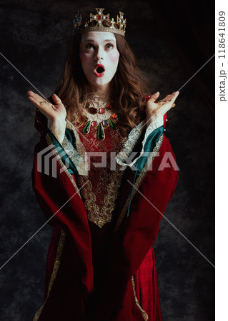 shocked medieval queen in red dress with white makeup 118641809