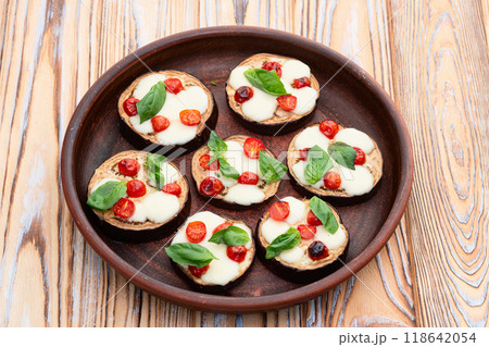 Italian mini pizza . Aubergine (eggplant ) with mozzarella cheese and basil . On rustic background Italian mini pizza . Aubergine (eggplant ) with mozzarella cheese and basil . On rustic background 118642054