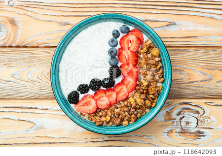 Healthy breakfast . Yogurt with berries ( strawberry , raspberry , blueberry , blackberry ) , granola and chia seeds . Top view 118642093