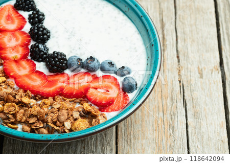 Healthy breakfast . Yogurt with berries ( strawberry , raspberry , blueberry , blackberry ) , granola and chia seeds . Top view 118642094