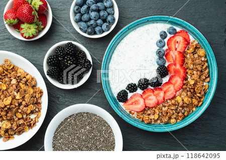 Healthy breakfast . Yogurt with berries ( strawberry , raspberry , blueberry , blackberry ) , granola and chia seeds . Top view 118642095