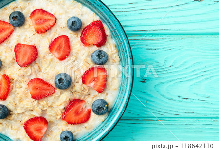 Homemade breakfast . Oatmeal with milk and berries . Top view Homemade breakfast . Oatmeal with milk and berries . Top view 118642110