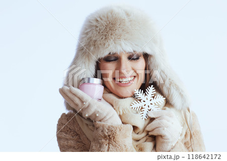smiling modern woman in winter coat and fur hat on white 118642172