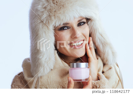 happy woman in winter coat and fur hat on white 118642177