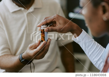 Close-up of patient receiving prescription bottle from healthcare professional during medical consultation, highlighting patient-provider interaction and focus on medication 118643008