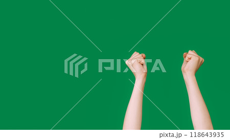Knocking fists. Protest gesture. Conflict demonstration. Female clenched hands striking showing opposition stop sign isolated on green empty space background. 118643935