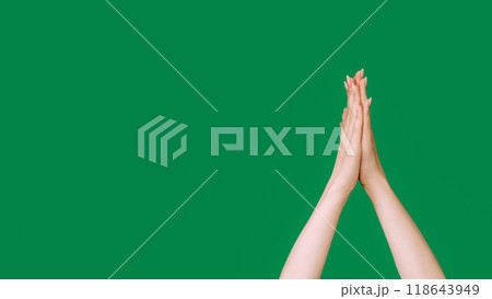 Praying gesture. Please help. Hope faith. Yoga meditation. Female raised folded hands begging sign isolated on green empty space background. 118643949