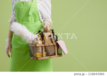 Modern woman in green apron and rubber gloves isolated on green Modern woman in green apron and rubber gloves isolated on green 118643960