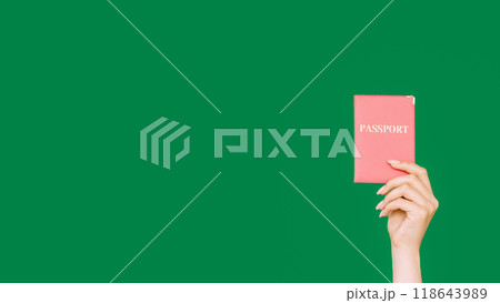 Passport document. Immigration service. Female hand showing citizenship ID in pink cover isolated on green empty space background. Passport document. Immigration service. Female hand showing citizenship ID in pink cover isolated on green empty space background. 118643989