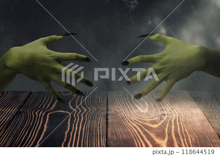 Two witches hand with long nail claw. The color is green. Evil, zombie, or monster hand is shown in a dark room. The scene is eerie and unsettling Two witches hand with long nail claw. The color is green. Evil, zombie, or monster hand is shown in a dark room. The scene is eerie and unsettling 118644519