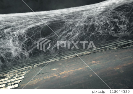 Spooky creepy cobweb spider web with grunge wall in the dark room. The scene is somewhat eerie and mysterious 118644529