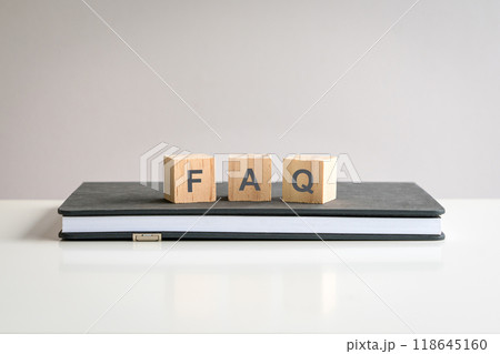 Text FAQ on wooden blocks on top of a notepad. Text FAQ on wooden blocks on top of a notepad. 118645160