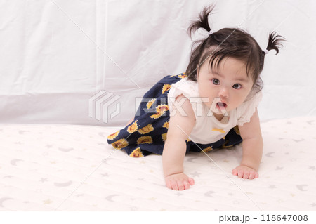 【はいはいを始める髪を結んだ赤ちゃん】 118647008