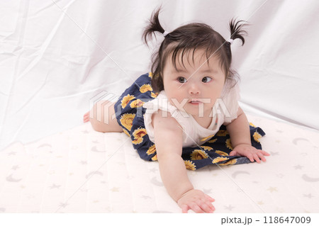 【はいはいを始める髪を結んだ赤ちゃん】 118647009