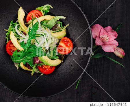 Fresh vegan salad with avocado, tomatoes and cucumber in black plate 118647545
