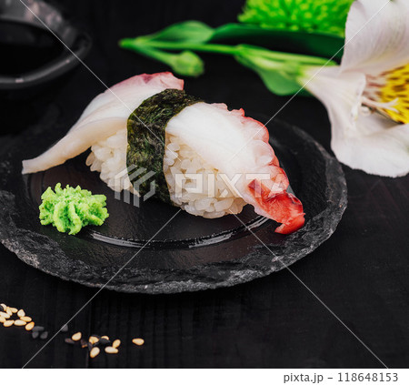 Delicious octopus sushi with wasabi resting on a black slate plate 118648153