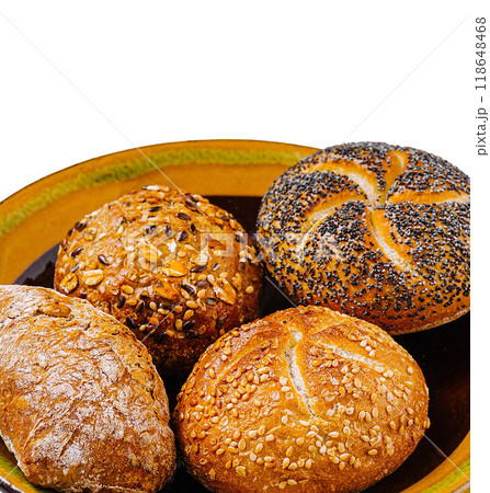 Four freshly baked bread rolls with sesame seeds, poppy seeds, and sunflower seeds on a plate Four freshly baked bread rolls with sesame seeds, poppy seeds, and sunflower seeds on a plate 118648468