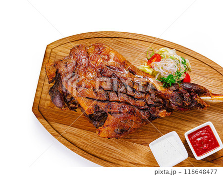 Roasted lamb leg with vegetables on wooden cutting board 118648477