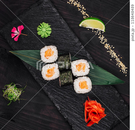 Salmon sushi rolls set served on black stone plate 118648489