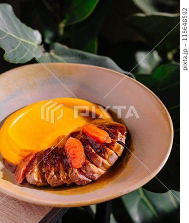Delicious duck breast with orange sauce and mashed sweet potatoes being served on a plate 118648592