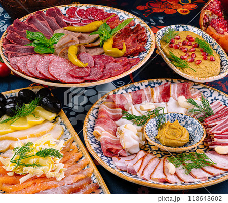 Variety of delicious meat snacks being served on plates 118648602