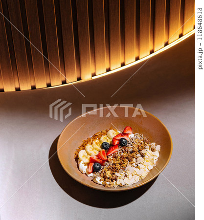 Delicious granola with yogurt and fruits serving on table in cafe 118648618