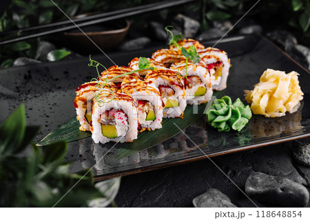 Fresh sushi rolls with eel and avocado being served on black plate 118648854