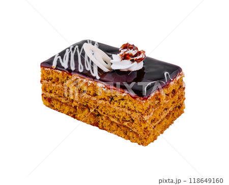 Delicious honey cake layered with chocolate glaze and topped with walnut and whipped cream 118649160
