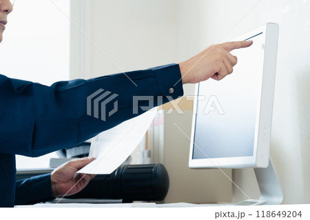 パソコンと資料を見比べる作業着の男性 パソコンと資料を見比べる作業着の男性 118649204