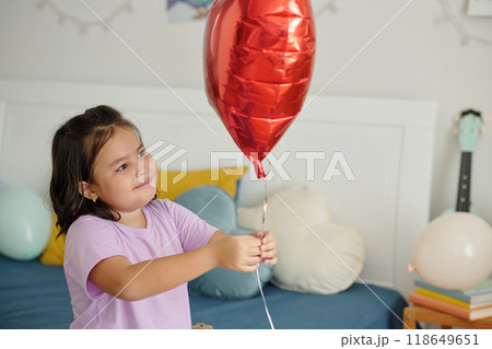Girl Playing With Balloon In Her Room 118649651