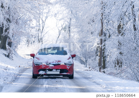 Car on a winter road through a snow covered forest 118650664
