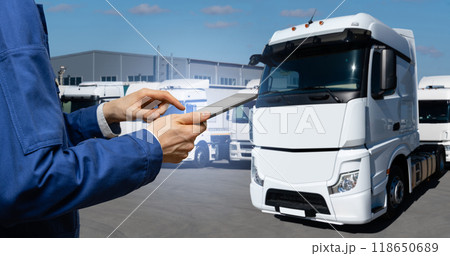 Fleet manager with digital tablet on a background of trucks. 118650689