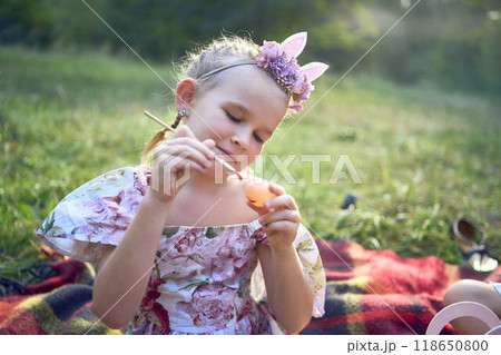 a llittle girl  paint eggs at the easter picnic 118650800