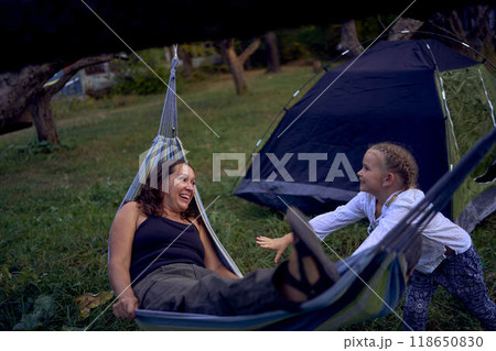 mother with little daughters playing together in  hammock, camping with children 118650830