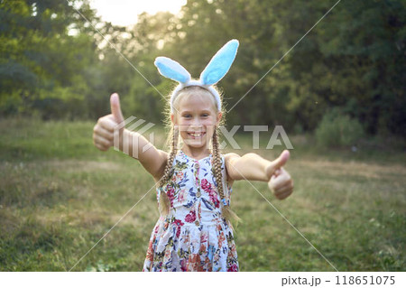 llittle girl play bunnies on an Easter egg hunt llittle girl play bunnies on an Easter egg hunt 118651075