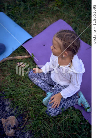 mother and her daughters  roasting and eating marshmallows on the campfire, camping vacation with children, mosquito bites on children's faces 118651098