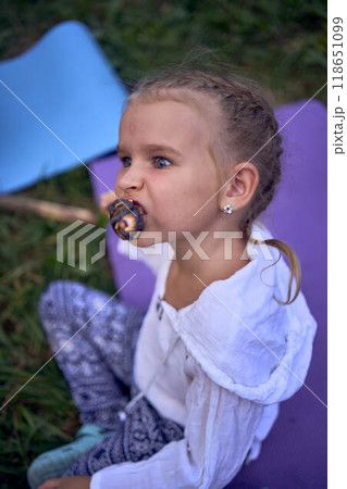 mother and her daughters  roasting and eating marshmallows on the campfire, camping vacation with children, mosquito bites on children's faces 118651099