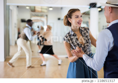 Cheerful female practicing lindy hop in pair with man 118651317