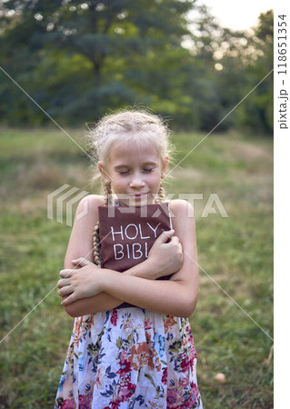 little girls sisters pray to god at easter picnic in garden 118651354