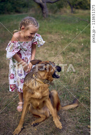 little girls sisters play with german shepherd dog during easter picnic in the garden 118651375