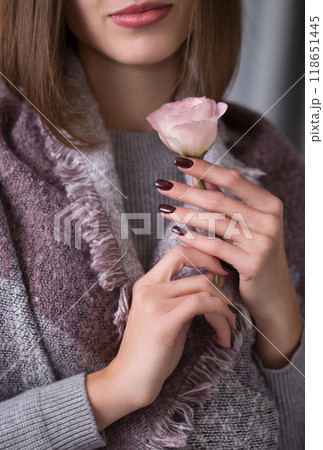 A young woman holds a pink eustoma flower in her hands, close-up A young woman holds a pink eustoma flower in her hands, close-up 118651445