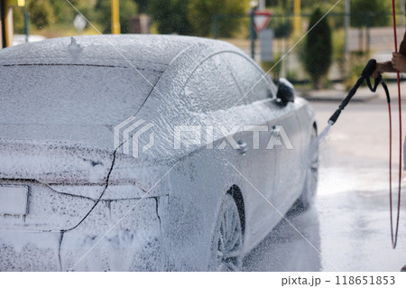 Cleaning car using active foam. Handsome man washing his luxury car on self car-washing 118651853