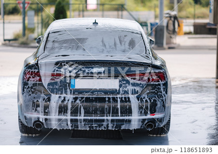 Luxury car all in white foam on self service car wash. Waiting. Back view Luxury car all in white foam on self service car wash. Waiting. Back view 118651893