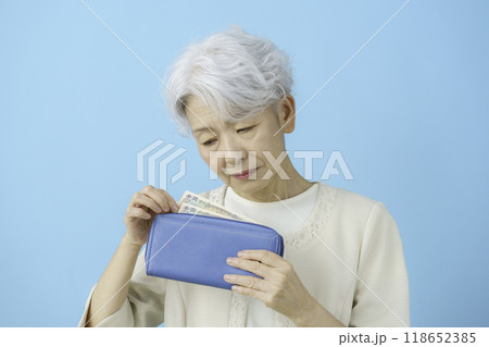 財布の中のお金を見て落ち込むシニア女性 財布の中のお金を見て落ち込むシニア女性 118652385