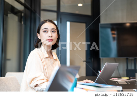 パソコン作業の合間に窓からの景色を見る女性 118653719