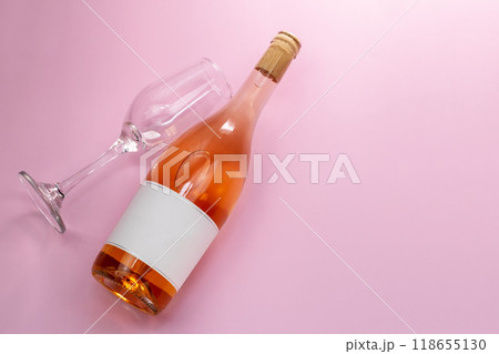 Wine bottle mockup, unopened bottle of rose wine and a glass on pink background, top view, copy space, flat lay 118655130