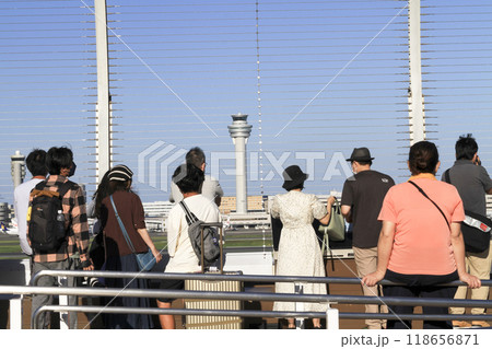 羽田空港の展望デッキで飛行機を見送る人達 118656871