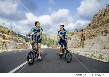 female and male cyclist riding bike together 118656945