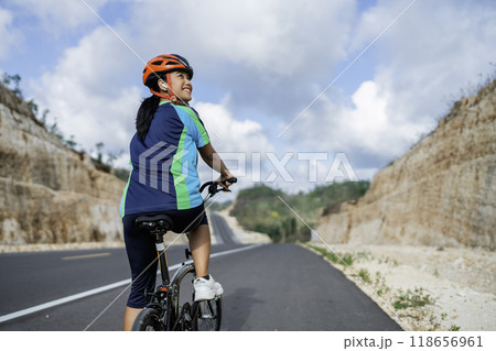 female biker riding bike on road female biker riding bike on road 118656961